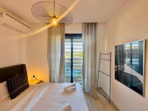 a bedroom with a bed and a large window at C1 Jade new cozy 1 bedroom with garden in Dar el Haj Ahmed Souid