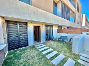 a house with a lawn in front of it at C1 Jade new cozy 1 bedroom with garden in Dar el Haj Ahmed Souid