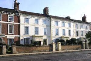 a large white building on the side of a street at The Langham Hotel in Northampton