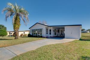 a palm tree in front of a white house at Lady Lake House with Lanai and Community Pool! in Lady Lake