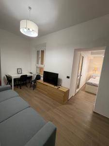 Una sala de estar con un sofá, una mesa y una cama. en Adriano Space, en Módena