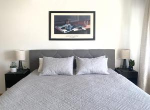 a bedroom with a bed with two nightstands and a framed picture at Apartment ANi I 2Zi Göppingen I Neues Bad I Terr & Garten I ruhig an Fahrradstraße I nahe EWS Arena I E-Parkplatz auf Anfrage in Göppingen