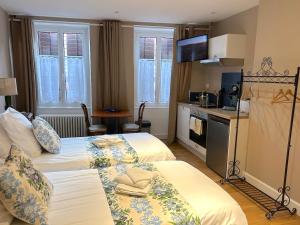 a hotel room with two beds and a kitchen at Hostellerie Alsacienne de Masevaux in Masevaux