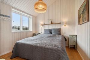 a bedroom with a bed and a window at Snug In Snogebæk A Modern Cozy Summer House in Neksø