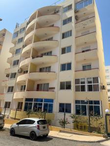 a white car parked in front of a building at Condominio atlantico ll in Praia