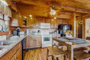 een keuken met houten kasten en een plafondventilator bij Fox Hollow in Little Cove
