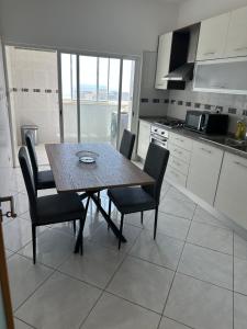 a kitchen with a table and chairs in a kitchen at Condominio atlantico ll in Praia