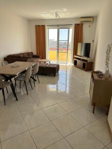a living room with a table and a couch at Condominio atlantico ll in Praia
