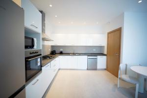 El HaouachにあるVilla Hermes: Seaside and luxuriousの白いキャビネットとテーブル付きのキッチン