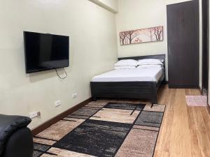 a bedroom with a bed and a flat screen tv at Cozy Staycation at Eastbay Residences in Manila +16 photos