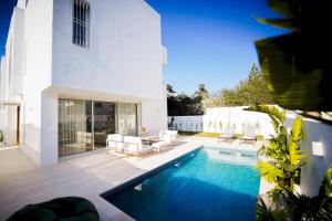 a villa with a swimming pool and a patio at Villa Apollon: Seaside and luxurious in El Haouach