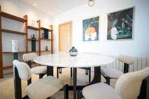 a dining room with a white table and chairs at Villa Apollon: Seaside and luxurious in El Haouach