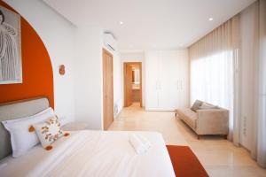 a bedroom with a bed and a couch in a room at Villa Apollon: Seaside and luxurious in El Haouach +19 photos