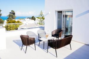 a patio with chairs and a table on a balcony at Villa Apollon: Seaside and luxurious in El Haouach