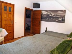 a bedroom with a bed and a mirror and a door at Salamonówka in Szlachtowa