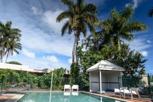 einen Pool mit Pavillon und Palmen in der Unterkunft Bundaberg International Motor Inn in Bundaberg