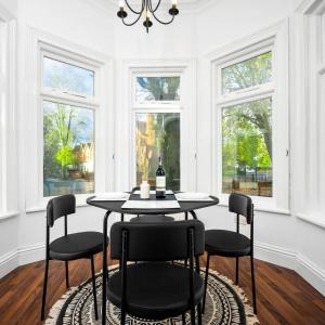 a dining room with a table and chairs and windows at Stylish Apartment - Wolverhampton - Fast Wi-Fi - Parking 9PC in Wolverhampton
