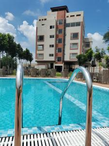 una piscina con una silla frente a un edificio en Zuke Garden & Resort, en Purulia