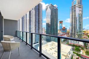 a balcony with two chairs and a view of a city at Gale Hotel Stay - Modern Condo Near the Bay in Miami