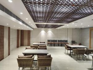 Un comedor con mesas y sillas en un edificio. en Zuke Garden & Resort, en Purulia