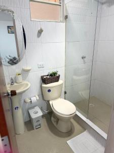 a bathroom with a toilet and a sink and a shower at Apartamento Limón Azul in Sogamoso