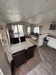 Una cocina y una sala de estar con mesa y sillas. en Seaview Holiday Rentals - Hailsham, en Chestfield