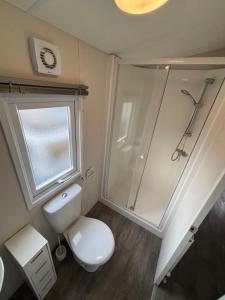 Un baño con inodoro blanco y ducha. en Seaview Holiday Rentals - Hailsham, en Chestfield 6 fotos más