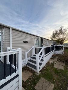 una casa con una barandilla blanca y una escalera en Seaview Holiday Rentals - Hailsham, en Chestfield