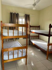 a room with three bunk beds and a window at Porto Pousada in Imbituba
