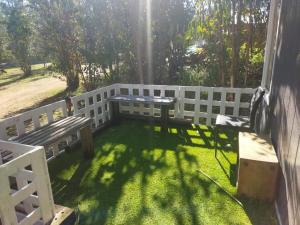 a patio with two benches and a fence at Cabañas Entre Bosques De Algarrobo in Algarrobo