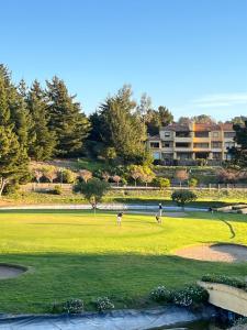 a group of people playing golf on a golf course at Departamento Costa Quintay in Quintay
