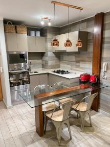 a kitchen with a glass dining table and chairs at Departamento Costa Quintay in Quintay