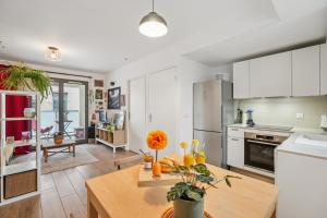 uma cozinha com armários brancos e uma mesa de madeira em " Casa Nova " Cosy et calme en hypercentre em Lyon