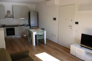 a living room with a table and a kitchen at Flamingo Houses in Quartu SantʼElena