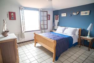 Casa em Buzios Proxima da Praia - BRD2 في بوزيوس: غرفة نوم بسرير والجدران الزرقاء ونافذة +63 صورة