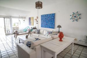 Casa em Buzios Proxima da Praia - BRD2 في بوزيوس: غرفة معيشة مع أرائك بيضاء وطاولة