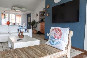 Casa em Buzios Proxima da Praia - BRD2 في بوزيوس: غرفة معيشة مع أريكة وتلفزيون