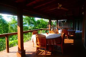 a patio with a table and chairs on a porch at Framadani estate entire property - 3BDR Villa with pool and 1BDR Cabin in San Ignacio