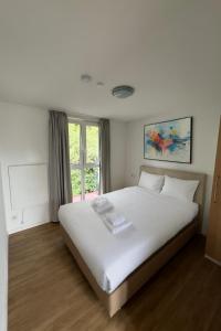 a large white bed in a room with a window at Work & Travel Lodge Münsingen in Münsingen