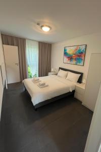 a bedroom with a large white bed and a window at Work & Travel Lodge Münsingen in Münsingen
