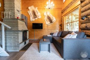 a living room with a couch and a fireplace at HilleVilla by Holiday in Lapland in Ylläsjärvi