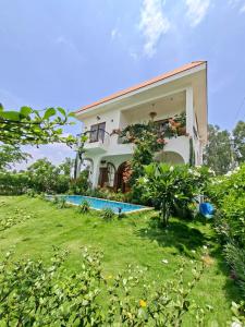 a house with a yard and a swimming pool at Tuscan Breeze, Nandi Hills in Nandigunda