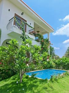 a house with a balcony and a swimming pool at Tuscan Breeze, Nandi Hills in Nandigunda