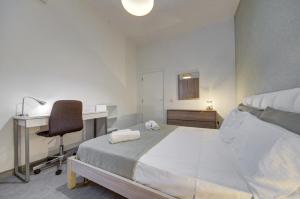 a bedroom with a bed and a desk and a chair at Forum Swieqi, Luxury Apartment, 2BD-2BH, Sleeps 4 in Is-Swieqi