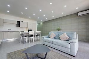 a living room with a couch and a table and a kitchen at Forum Swieqi, Luxury Apartment, 2BD-2BH, Sleeps 4 in Is-Swieqi