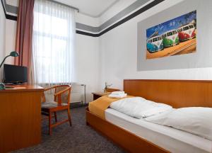 sypialnia z łóżkiem i biurkiem z komputerem w obiekcie Hotel Neun 3/4 w mieście Celle