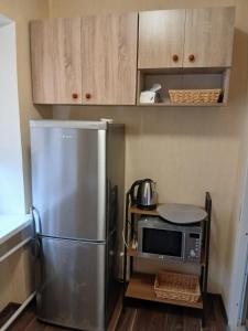 uma cozinha com um frigorífico de aço inoxidável e um micro-ondas em Уютный уголок em Narva