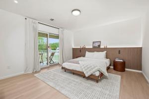 a white bedroom with a bed and a large window at Pond House at Carter Bridge Estate in Freehold