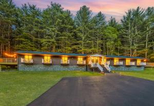 a home in the woods with lights on at Pond House at Carter Bridge Estate in Freehold