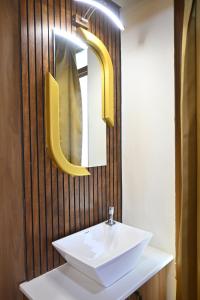 a bathroom with a white sink and a mirror at Marudhan Grand in Kumbakonam +34 photos